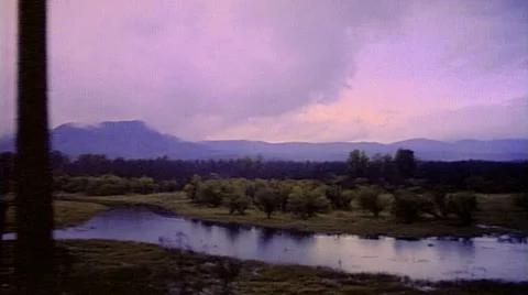 Point of view from train passenger window of western scene with water and trees Stock Footage 29807866