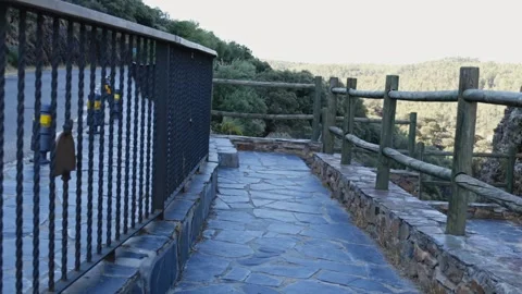 Point of view walking along a stone pathway with wooden railings overlooking Stock Footage 339432888