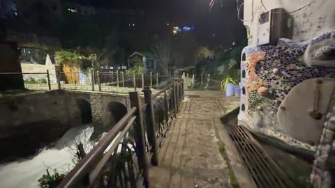 Point of view walking on a wet cobblestone path next to a flowing river Stock Footage 339498579