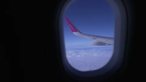 Point of view from the window of the plane of the wing flying above white clouds Video stock 122287156