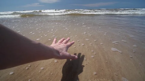 Point of view young Man hand reaching Ocean sea arm Sand shore Waves slow motion Stock-Footage 128524253