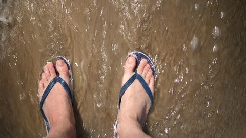 Point of view Young Man standing on Beach. Male legs with flip flops Ocean Sandy Stock Footage 128526408