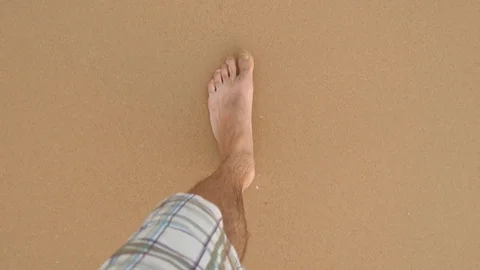 Point of view of young man stepping at the golden sand at sea beach. Male legs Stock Footage