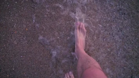 Point of view of young man stepping at the sand at beach at sunset. Slow motion Stock Footage 95147219