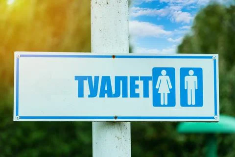 Pointer arrow in the form of a sign on the street the inscription "WC" in Rus Stock Photos