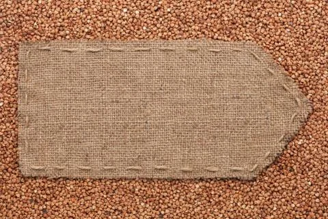 Pointer of burlap lying on a buckwheats background Stock Photos
