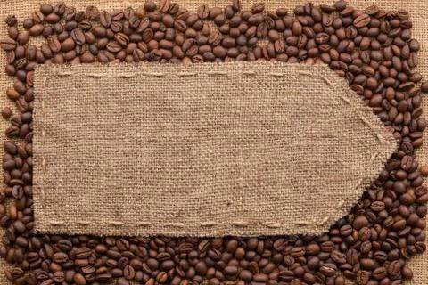 Pointer of burlap lying on a coffee beans background Stock Photos