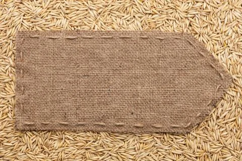 Pointer of burlap lying on a oats background Stock Photos