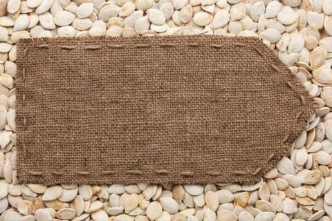 Pointer of burlap lying on a pumpkin seeds background Stock Photos