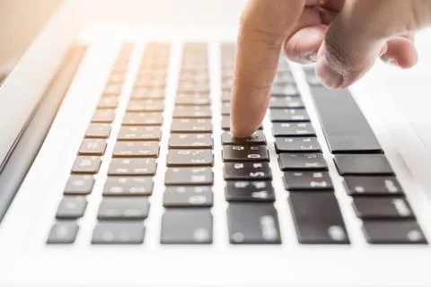 Pointer finger press a button on laptop keyboard Stock Photos