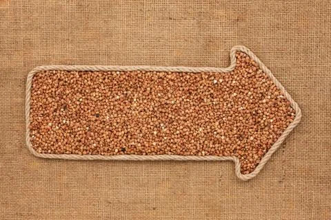 Pointer made from rope with grain buckwheat  lying on sackcloth Stock Photos