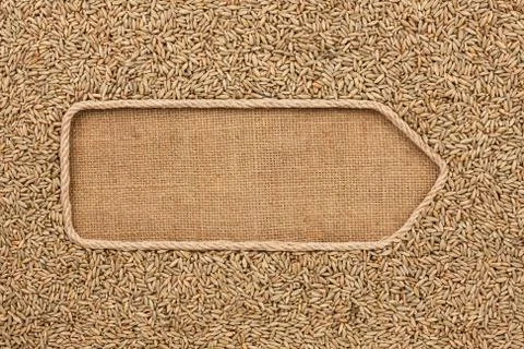 Pointer made from rope with grains rye lying on sackcloth Stock Photos