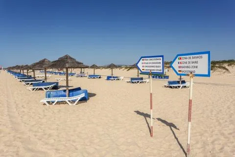 Pointers for a recreation area for sunbathing. Sun beds and umbrellas. Stock Photos
