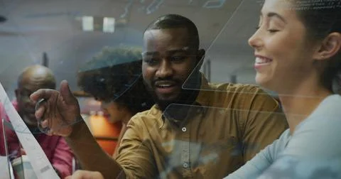 Pointing brown-shirted developer explaining interface code in open office, with Stock Photos