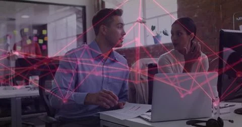 Pointing colleagues discussing data flow at office desk with sticky notes, Stock Photos