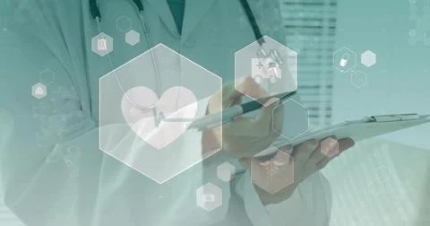 Pointing doctor using hex icons in clinic holding tablet, pen, wearing white Stockfoto's