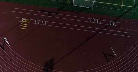 Pointing down at the tracks and then revealing the football field sun rays Stock Footage 82328995
