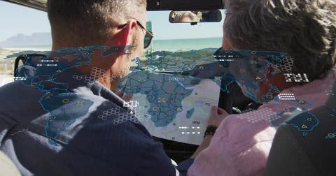Pointing driver, leaning passenger studying map in car, windshield showing AR Foto stock