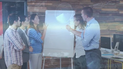 Pointing male presenter guiding team at office while woman in blue-striped top Stock Footage 331005958