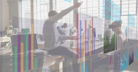 Pointing male speaker explaining data at open office, in light sweater, showing Stock Photos