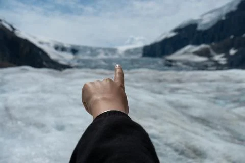Pointing at a snowy glacier between two snow covered mountains Stock Photos