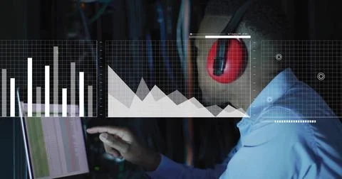 Pointing tech in light blue shirt, red headset, touching data-center screen with Foto stock