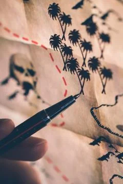 Pointing on a treasure map at the computer screen with pen Stock Photos