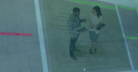 Pointing two pros talking in lobby laptop or tablet code overlay on tiled-floor 스톡 사진