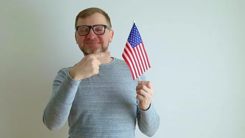 Points to the flag in his hands. Immigration to the United States of America. Stock Footage 240108452