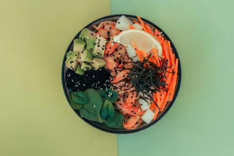 Poke bowl with shrimp. top view on a green background Stock Photos