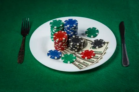 Poker chips and dollars on a plate on the poker table Stock Photos