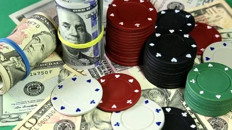 Poker chips and dollars on rotating surface. Stock Footage 73988889