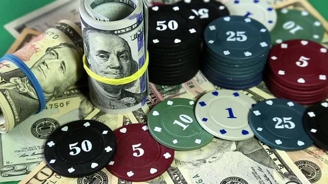 Poker chips and dollars on rotating surface. Stock Footage 73988896