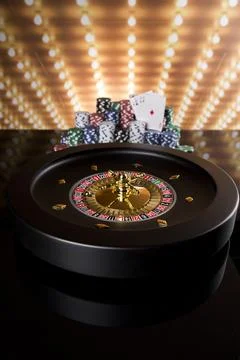 Poker Chips on gaming table, roulette wheel in motion, casino background Stock Photos