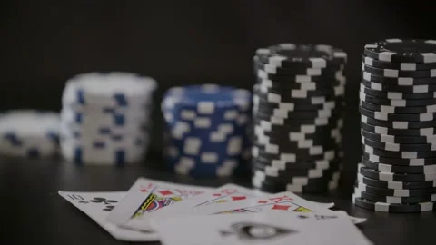 Poker-chips-stack-with-cards-on-black-table Stock Footage 150428040