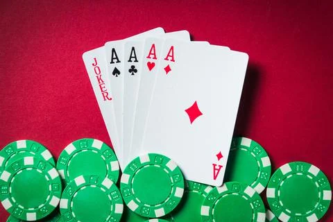 Poker game with five of kind combination. Chips and cards on the red table. Stock Photos