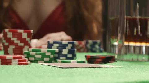 Poker player checking his hand, holding Queen and King combination chips cards Stock Footage 125983104
