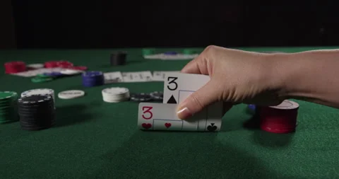 Poker Player Considers Next Move with two threes Stock Footage 243251887