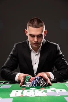Poker player going all in pushing his chips forward casino Stock Photos