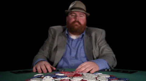 Poker player plays with chips in the pot as he drags them toward him and laughs Stock Footage 53234579