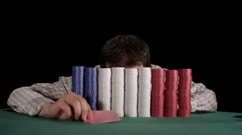 Poker player pops up from behind large stacks of chips and counts his stacks Stock Footage 53240183