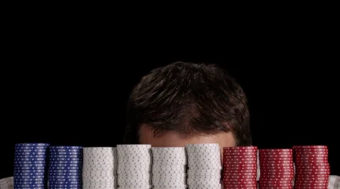 Poker player reveals himself from behind large stacks of chips and smiles Stock Footage 53235752