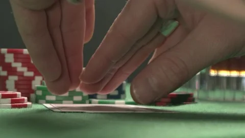Poker player with a tattoo checking his hand, having a pair of jacks. Stock Footage 205718145