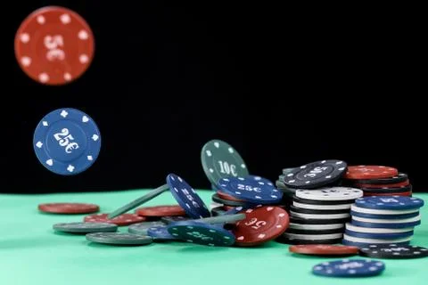 Poker playing chips on a green table and black background. Online gambling. Stock Photos