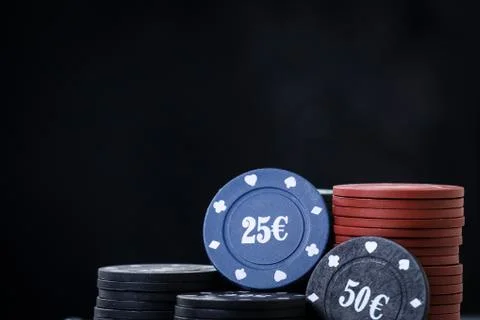 Poker playing chips on a reflected table and black background. Online gambling. Stock Photos