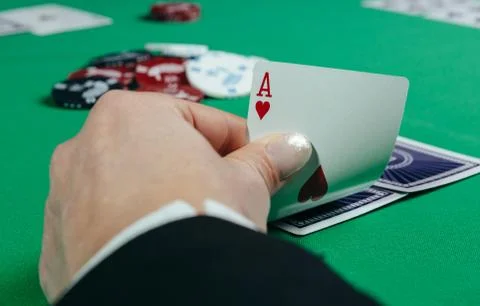 Poker table during a game. Four aces cards holding in hand. Chips and cards o Foto stock