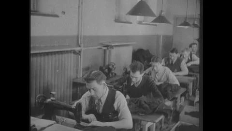 POLAND 1930s: Men work at sewing machines in a tailoring workshop, seated at Stock Footage 342072024