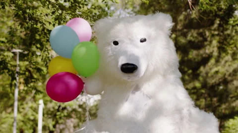Polar bear life-size puppet make a funny walk close up in a city park with a Stock Footage 243520394