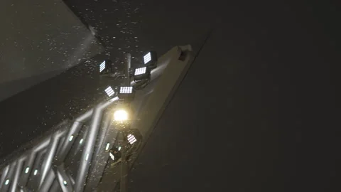 Pole with cluster of spotlights shines beam in darkness Видео 326464521