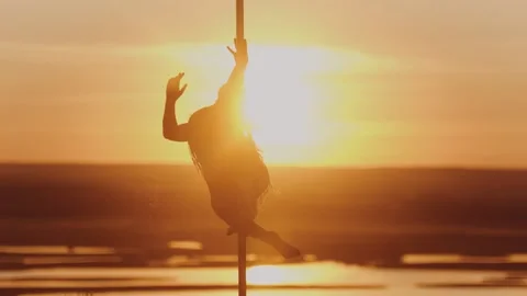Pole dance on bright sunset - acrobatic woman dancing Stock Footage 136558834